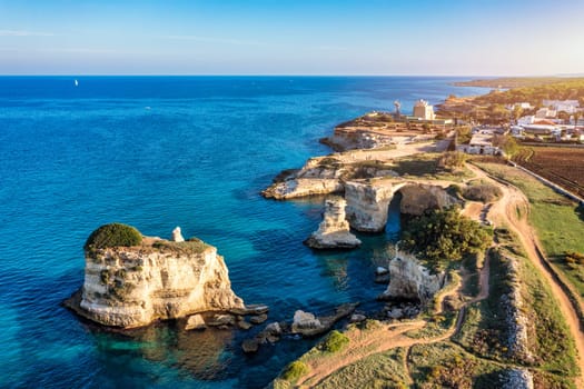 Stunning seascape with cliffs rocky arch and stacks (Faraglioni) at Torre Sant Andrea, Salento coast, Puglia region, Italy. Beautiful cliffs and sea stacks of Sant'Andrea, Salento, Apulia, Italy