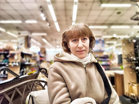 Girl while shopping in a store. A middle-aged woman chooses shopping on the trading floor