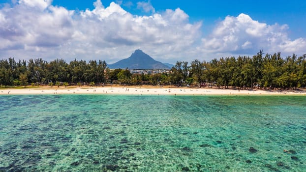 Beach of Flic en Flac with beautiful peaks in the background, Mauritius. Beautiful Mauritius Island with gorgeous beach Flic en Flac, aerial view from drone. Flic en Flac Beach, Mauritius Island.