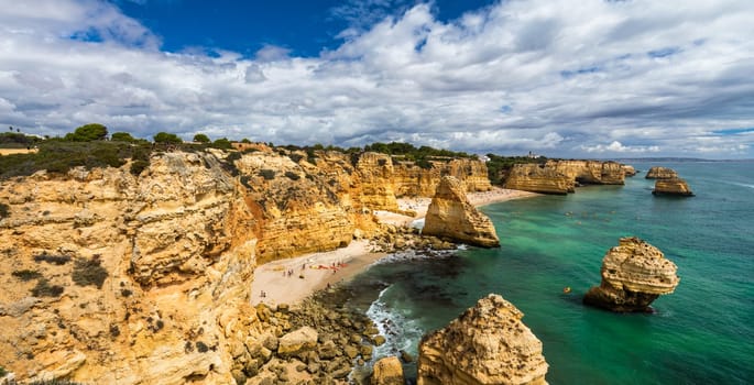 Praia da Marinha, beautiful beach Marinha in Algarve, Portugal. Navy Beach (Praia da Marinha) with flying seagulls over the beach, located on the Atlantic coast in Lagoa Municipality, Algarve.