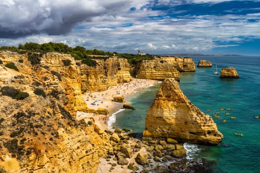 Praia da Marinha, beautiful beach Marinha in Algarve, Portugal. Navy Beach (Praia da Marinha) with flying seagulls over the beach, located on the Atlantic coast in Lagoa Municipality, Algarve.