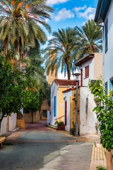 A small building with a blue door sits in front of a large Mosque with a tall tower in Nicosia, Cyprus. Beautiful street with old architecture in Nicosia, Cyprus.