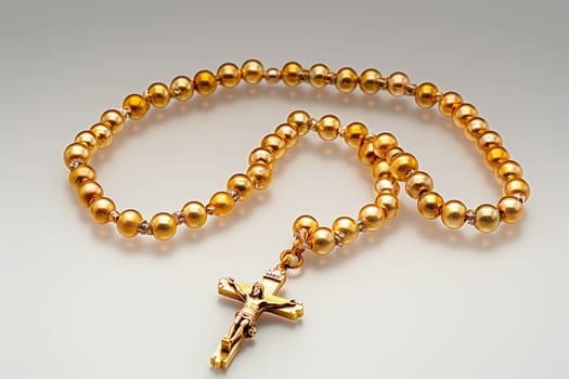 A gold rosary adorned with a cross hanging as a symbolic religious artifact.