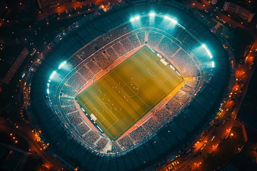 An overhead shot of a brightly lit soccer stadium during a night game, with players on the field and spectators in the stands.