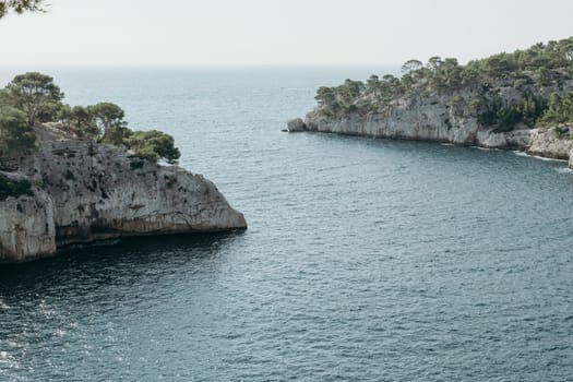 Beautiful view of the entrance of the bay between two rocky mountains with vegetation in the Mediterranean sea on a summer day in the calanques in France, close-up side view with depth of field.