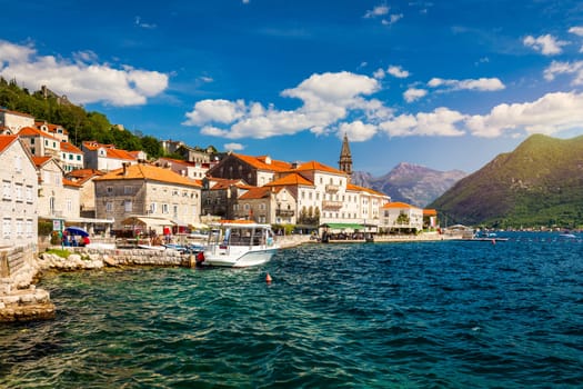 View of the historic town of Perast at famous Bay of Kotor on a beautiful sunny day with blue sky and clouds in summer, Montenegro. Historic city of Perast at Bay of Kotor in summer, Montenegro.