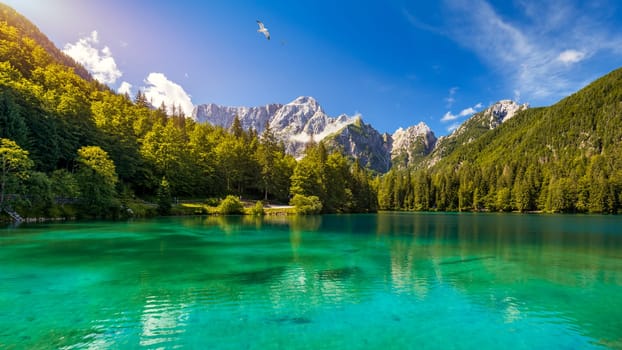 Picturesque lake Lago Fusine in Italy. Fusine lake with Mangart peak on background. Popular travel destination of Julian Alps. Location: Tarvisio comune , Province of Udine, Italy, Europe.