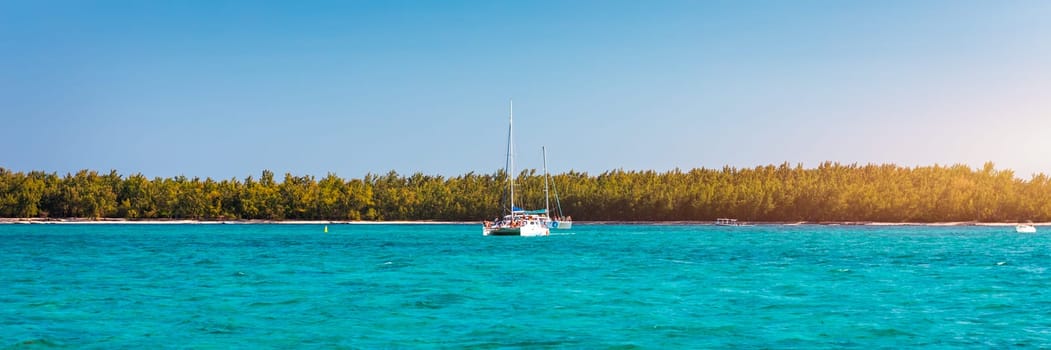 Beautiful catamaran in the paradise turquoise lagoon of the east coast of Mauritius. View of the lagoon of Mauritius in the Indian Ocean. 