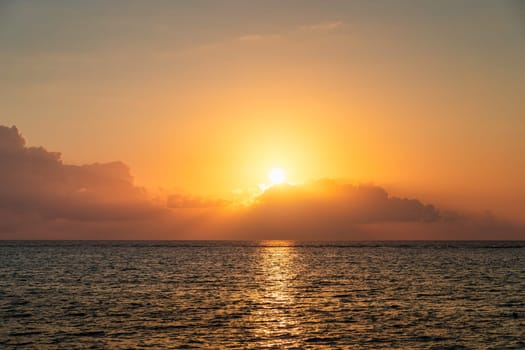 Dramatic colorful sunset sky over sea. Cloudscape nature background. Beautiful sunset over the sea. Sunset over the sea and beautiful cloudscape.