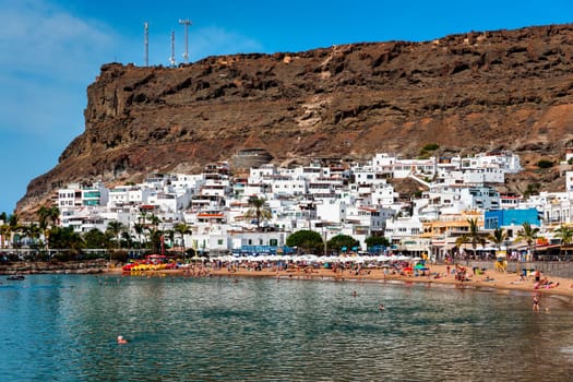 Puerto de Mogan with the beach in Gran Canaria, Spain. Favorite vacation place for tourists and locals on island. Harbor in Puerto de Mogan and Playa Mogan on Grand Canary Island, Spain.