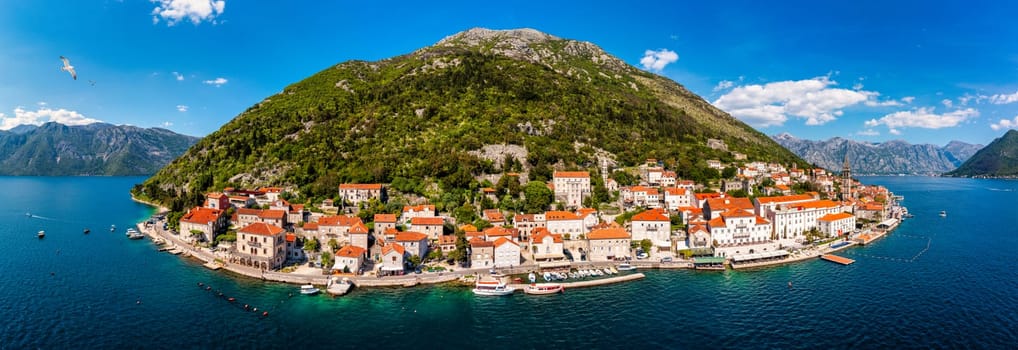 View of the historic town of Perast at famous Bay of Kotor on a beautiful sunny day with blue sky and clouds in summer, Montenegro. Historic city of Perast at Bay of Kotor in summer, Montenegro.