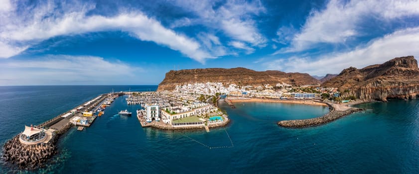 Puerto de Mogan with the beach in Gran Canaria, Spain. Favorite vacation place for tourists and locals on island. Harbor in Puerto de Mogan and Playa Mogan on Grand Canary Island, Spain.