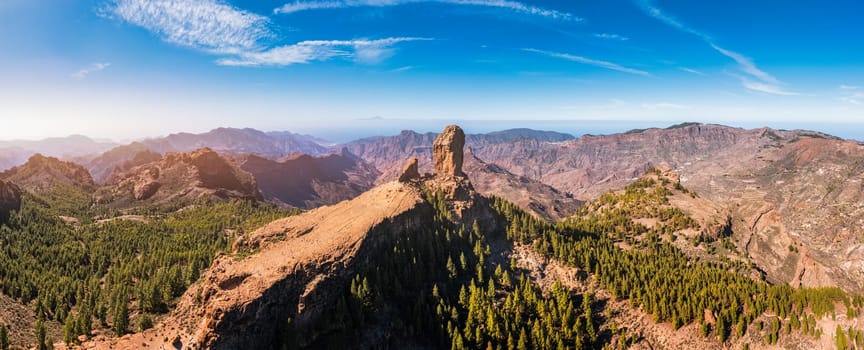 Roque Nublo and Pico de Teide in the background on Gran Canaria Island, Spain. Panoramic view of Roque Nublo sacred mountain, Roque Nublo Rural Park, Gran Canary, Canary Islands, Spain.