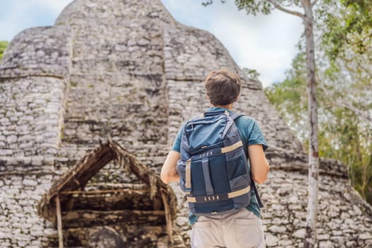 Man tourist at Coba, Mexico. Ancient mayan city in Mexico. Coba is an archaeological area and a famous landmark of Yucatan Peninsula. Cloudy sky over a pyramid in Mexico.