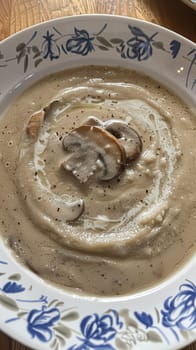 Mushroom cream soup served on a table in the garden