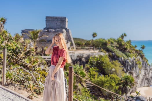 Woman tourist enjoying the view Pre-Columbian Mayan walled city of Tulum, Quintana Roo, Mexico, North America, Tulum, Mexico. El Castillo - castle the Mayan city of Tulum main temple.