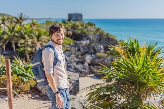 Man tourist enjoying the view Pre-Columbian Mayan walled city of Tulum, Quintana Roo, Mexico, North America, Tulum, Mexico. El Castillo - castle the Mayan city of Tulum main temple.