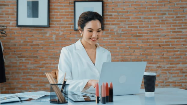 Young businesswoman sitting on the workspace desk using laptop computer for internet online content writing or secretary remote working from home. Vivancy