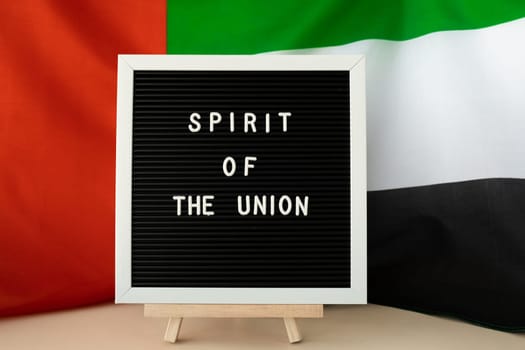 SPIRIT OF THE UNION text frame on United Arab Emirates waving flag made from silk material. Independence Commemoration Day Muslim Public holiday celebration background. The National Flag of UAE. Patriotism