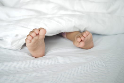 Bare feet of a child on white