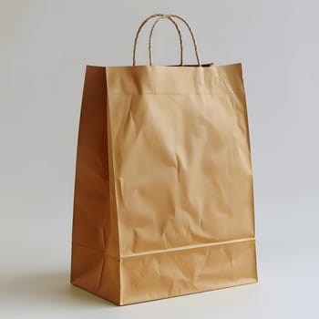 A brown paper bag, a rectangle fashion accessory, is creatively placed on a white surface. It stands out among other luggage and bags with its beige color and peach accents, resembling a shoulder bag