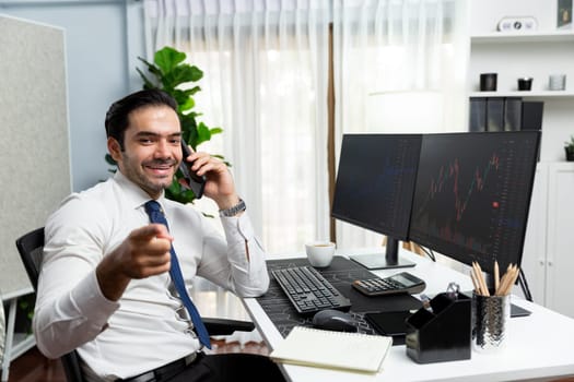 Trader businessman calling to consultant looking at camera with two stock exchange investment, compare data analysis to invest high profit dynamic financial technology stock market at office. Surmise.