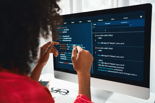 African American woman's programing developer. Coding Software project on computer screen server at home office. Concept of website designer in coder network information at work space. Tastemaker.