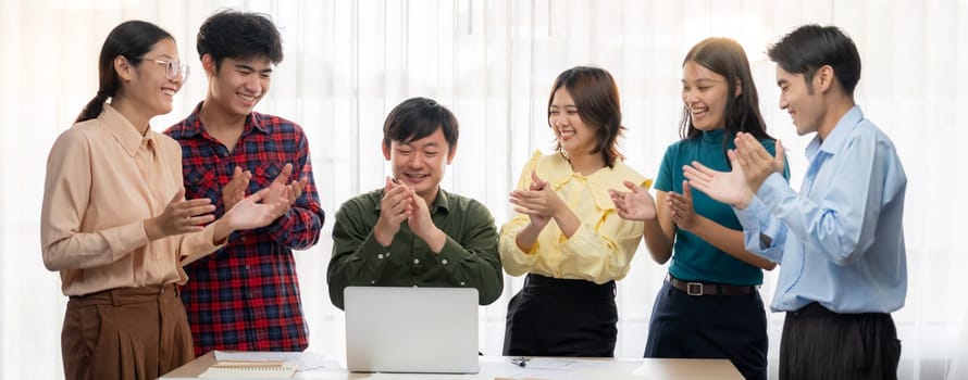 A portrait of Happy professional business team clap their hands to celebrate successful business project at modern office meeting room. CEO and employee celebrate their company success. Delineation.