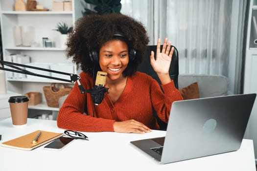 Host channel of beautiful African woman talking in online broadcast teaching marketing influencer, with listeners in broadcast or online. Concept of anywhere at work place. Tastemaker.