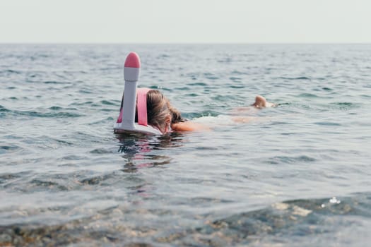 Young happy woman in white bikini put pink snorkeling mask on beach before swimming. girl having fun relaxing on beautiful beach. Beach lifestyle