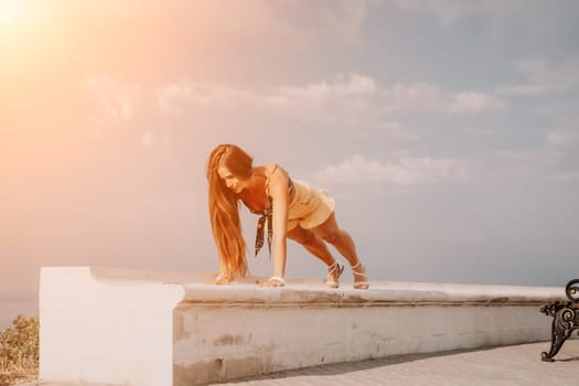 Woman park yoga. Side view of free calm bliss satisfied woman with long hair standing in morning park with yoga position against of sky by the sea. Healthy lifestyle outdoors in park, fitness concept