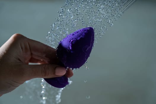 Woman washing her purple anal plug in the shower