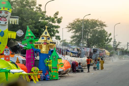 Jaipur, Rajasthan, India - 22nd oct 2023: People walking in front of huge colorful effigies of Ravana made of paper on the hindu festival of Dussehra Vijayadashami