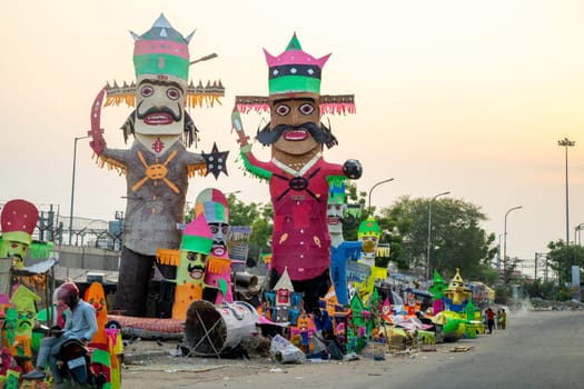 Jaipur, Rajasthan, India - 22nd oct 2023: People walking in front of huge colorful effigies of Ravana made of paper on the hindu festival of Dussehra Vijayadashami