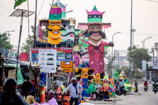 Jaipur, Rajasthan, India - 22nd oct 2023: People walking in front of huge colorful effigies of Ravana made of paper on the hindu festival of Dussehra Vijayadashami