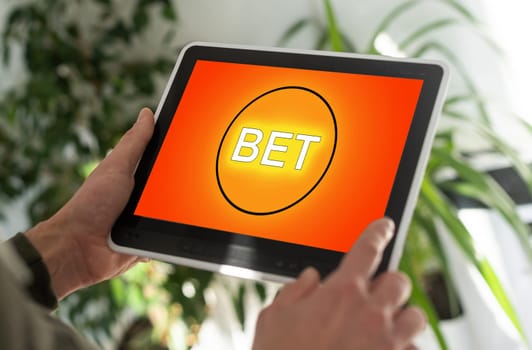 man placing bet with tablet computer, closeup.