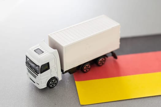 Mini toy at table with blurred background. Industrial shipping concept. toy truck, germany flag. High quality photo