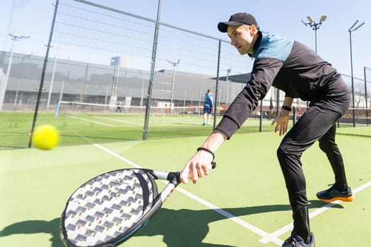 Paddle tennis player serving training with her couple in court. High quality photo