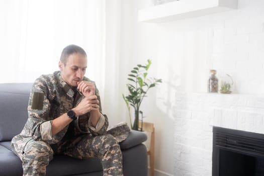 Sad Soldier In Uniform Praying and sitting . High quality photo