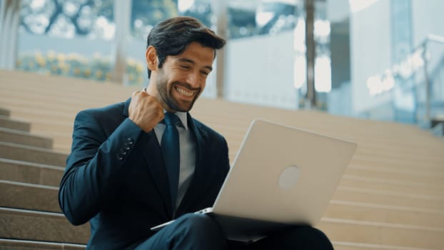 Smart business man working by using laptop while celebrate successful idea. Project manager get a job, know a good news by using laptop. Handsome caucasian investor wearing suit with bag. Exultant.