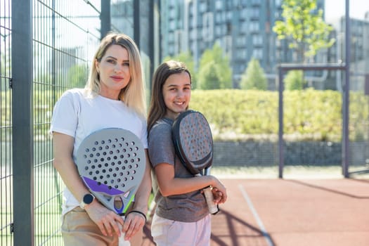 Beautiful girls getting ready for a workout on the padel tennis court. High quality photo