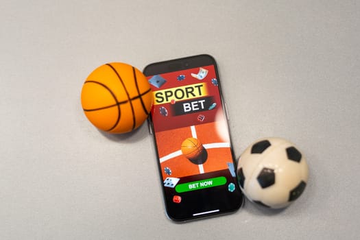 Sports betting website in a mobile phone screen, ball, money. High quality photo