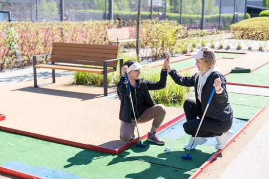 Family Time Playing Mini-Golf In The Summer. High quality photo