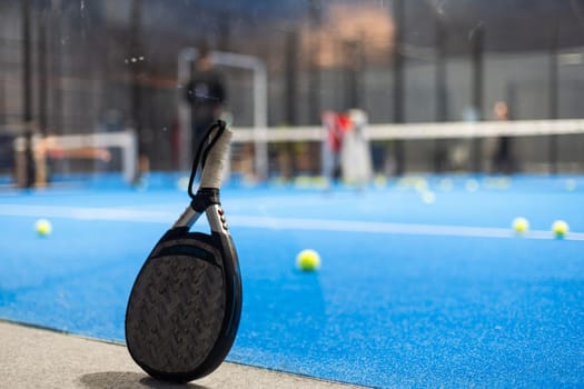 Paddle tennis: Paddel racket and ball in front of an outdoor court. High quality photo