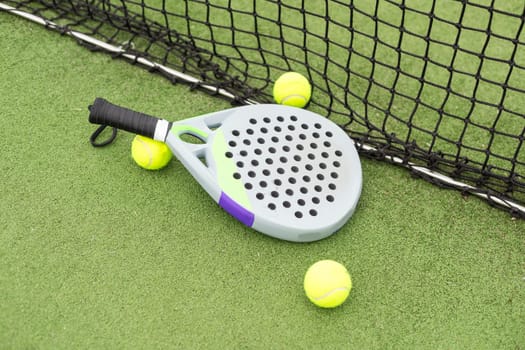 Paddle racket, next to the ball and on a carpet of the play area. High quality photo
