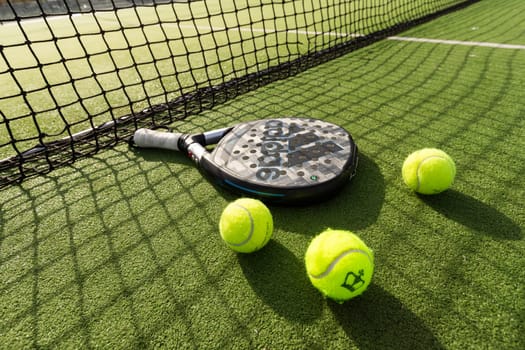 Ukraine Kyiv, 31.03.2024: Padel racket adidas and padel ball on a green court . High quality photo