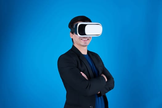 Profile of businessman arm crossing with wearing VR device looking to connect metaverse isolated blue background futuristic analytics communication technology virtual reality copyspace. Contrivance.