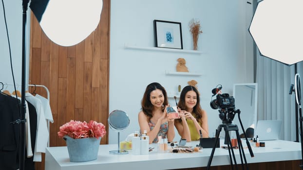 Two influencer partner shoot live streaming vlog video review makeup social media or blog. Happy young girl with vivancy cosmetics studio lighting for marketing recording session broadcasting online.