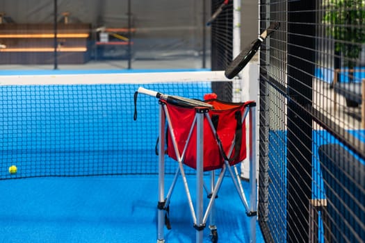 Paddle tennis rackets, balls and basket in court still life. High quality photo