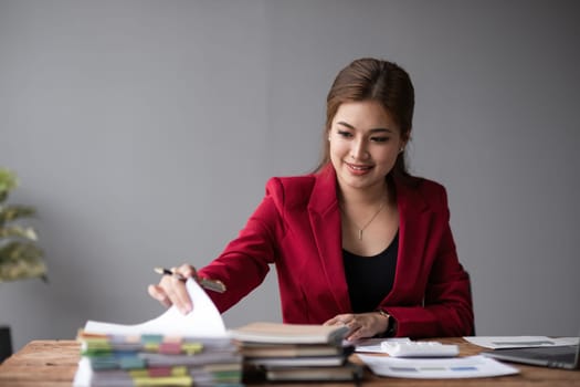 Accountant sitting with laptop calculating financial and tax figures for company on desk in office.